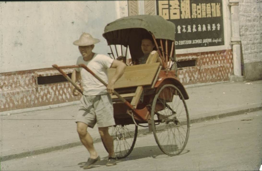 A person pushing a cart with a person in it

Description automatically generated with medium confidence