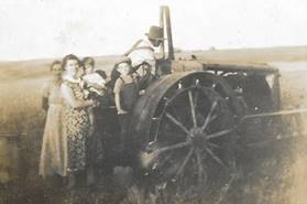 A group of people standing around a tractor

Description automatically generated with low confidence