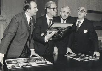 A group of men looking at a book

Description automatically generated with low confidence