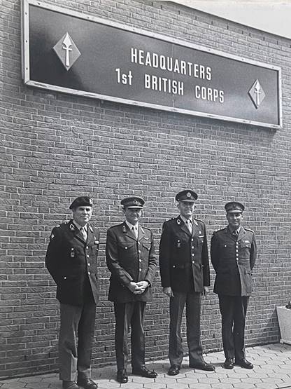 A group of men standing in front of a brick building

Description automatically generated with medium confidence