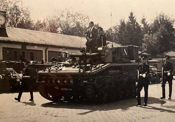 A group of men standing next to a tank

Description automatically generated with low confidence