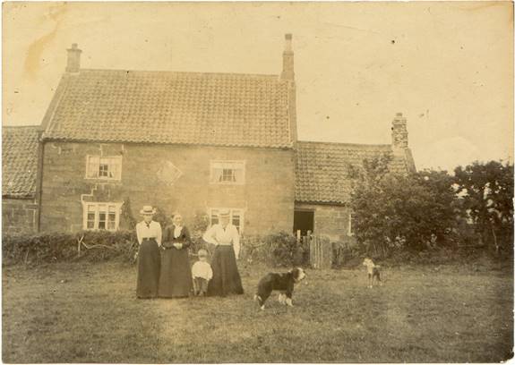 A family standing in front of a house

Description automatically generated