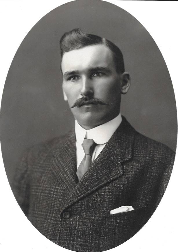 A vintage photo of a person in a suit and tie

Description automatically generated