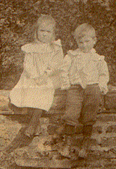 A couple of children sitting on a log

Description automatically generated
