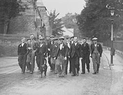 A group of men walking on a road

Description automatically generated