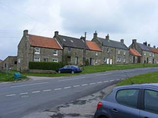 A row of houses on a street

Description automatically generated