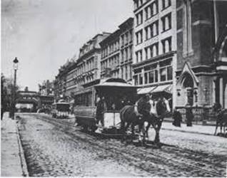 A horse drawn trolley on a street

Description automatically generated