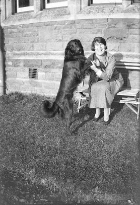 A person sitting on a bench with a dog
Description automatically generated