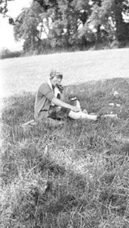 A person sitting in the grass
Description automatically generated