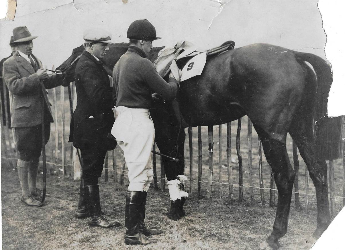 A group of men standing next to a horse
Description automatically generated