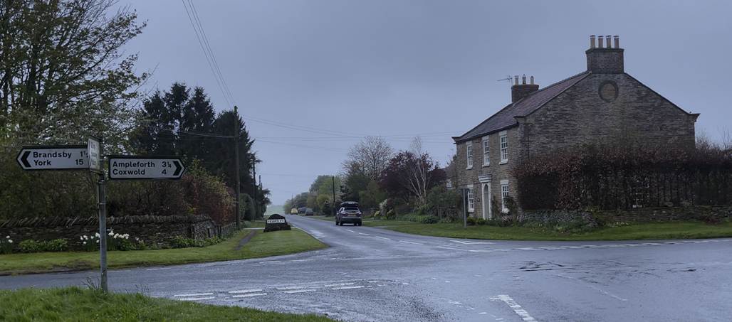 A computer screen shot of a road and houses

Description automatically generated