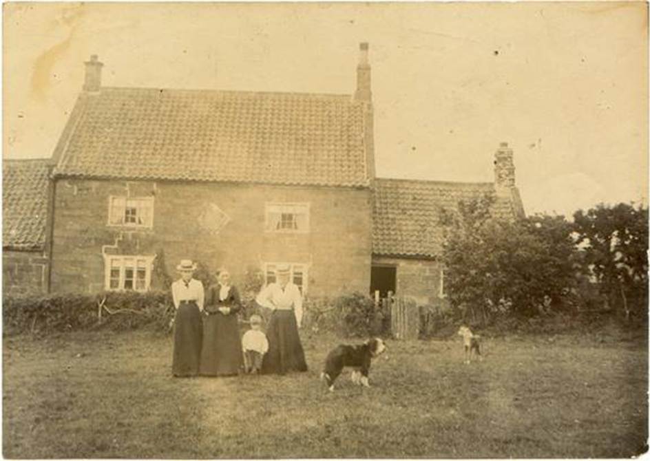 A group of people and dogs in front of a house
Description automatically generated