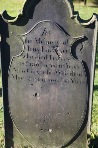 A tombstone with engraved text
Description automatically generated