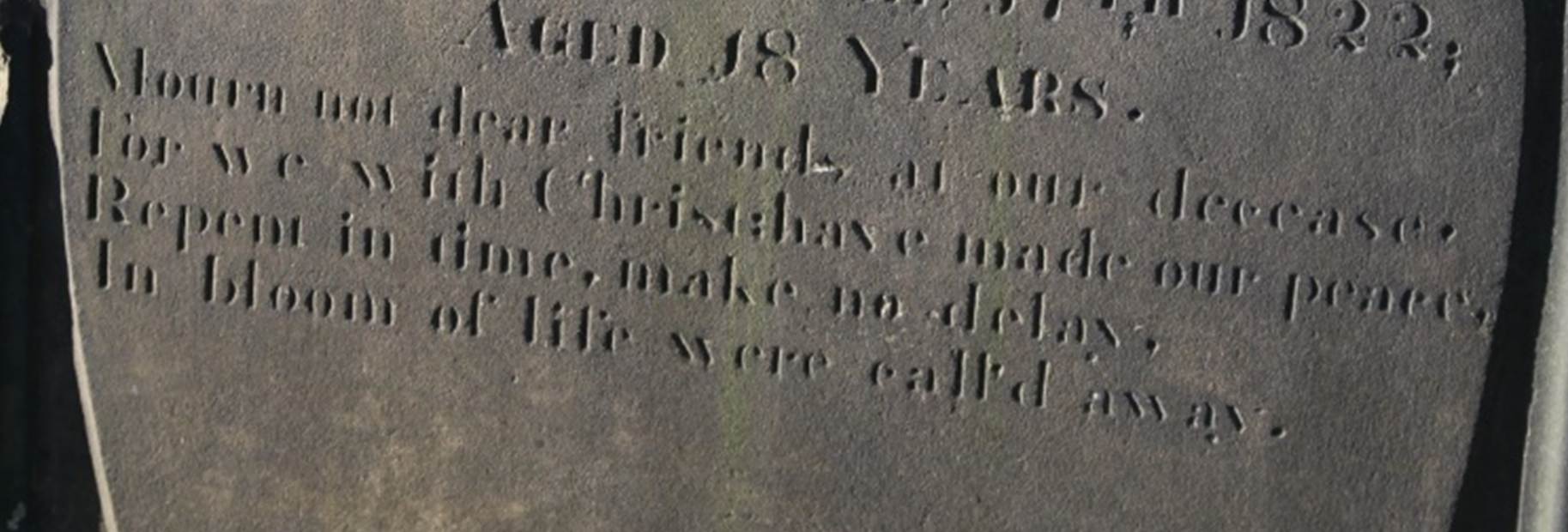 A tombstone in a cemetery
Description automatically generated