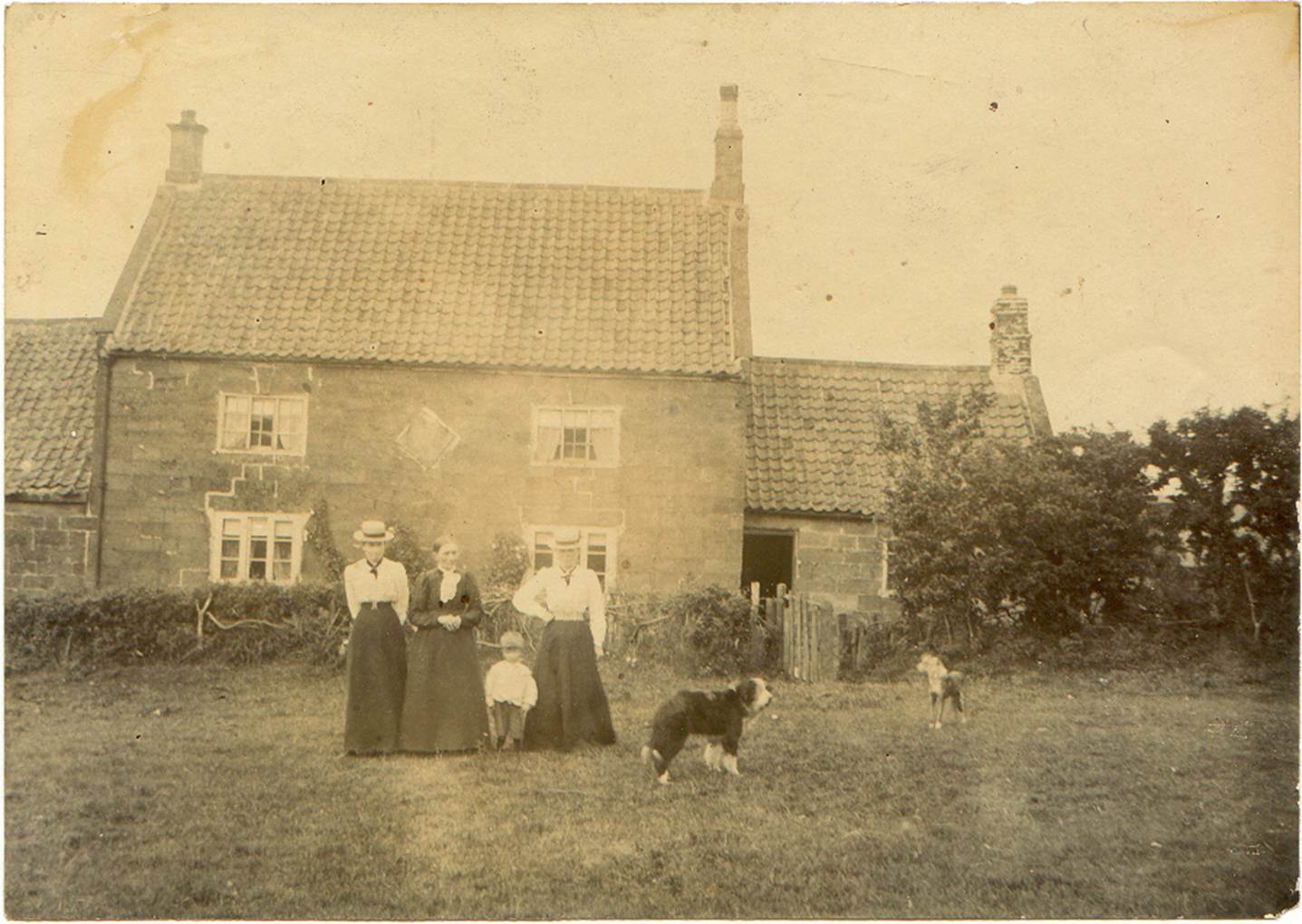A family standing in front of a house
Description automatically generated