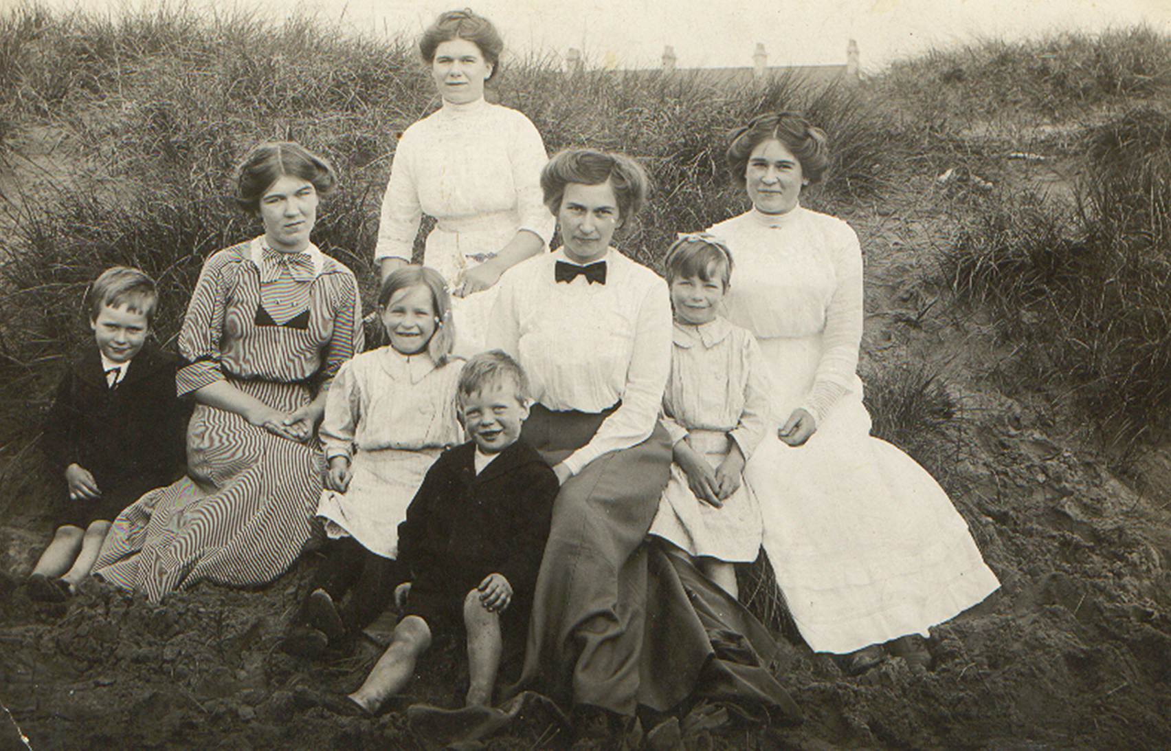 A vintage photo of a group of people posing for the camera
Description automatically generated