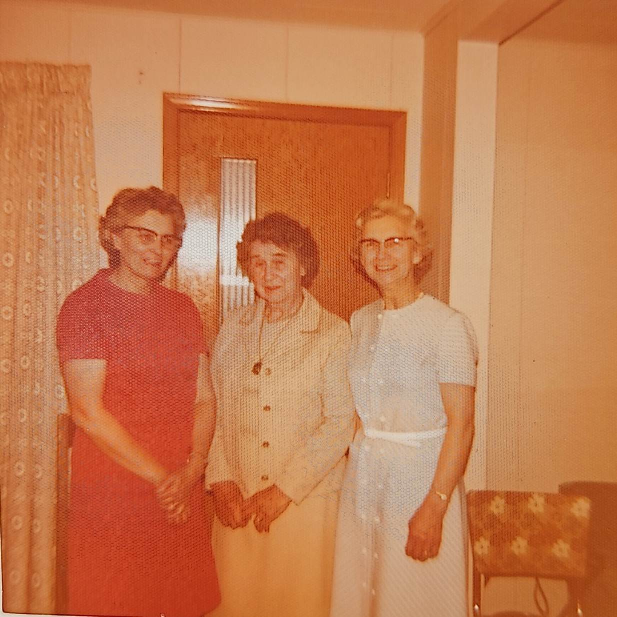A group of women standing in a room
Description automatically generated