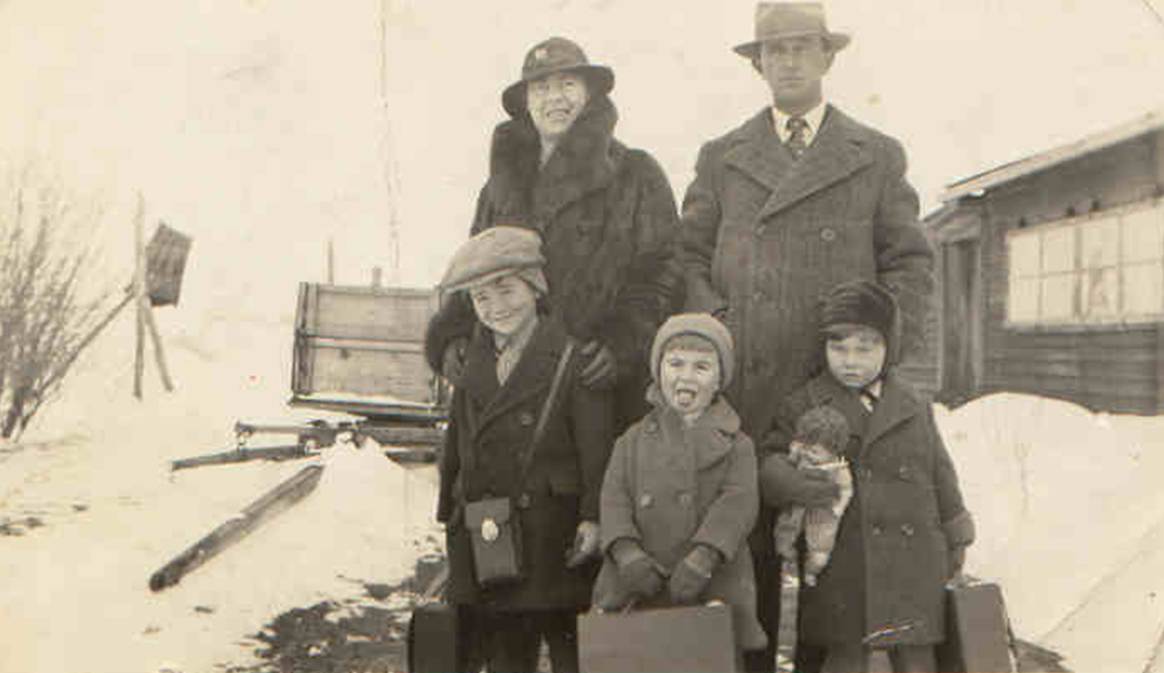 A family posing for a photo in the snow
Description automatically generated