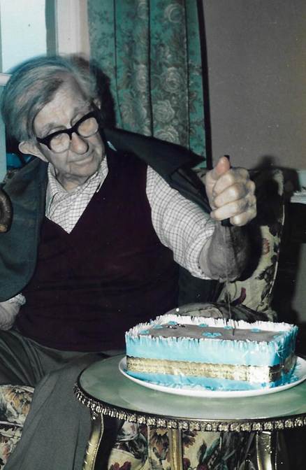 A person sitting at a table with a cake
Description automatically generated
