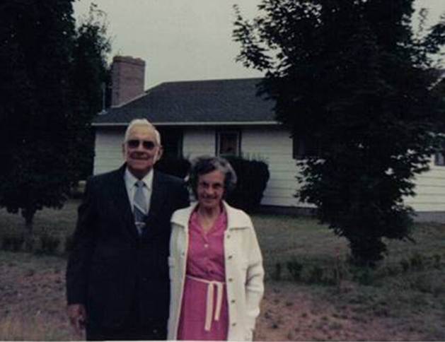 A person and person standing in front of a house
Description automatically generated