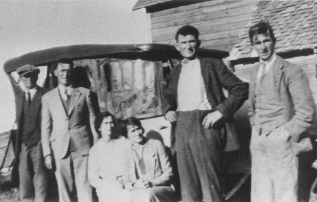 A vintage photo of a group of people posing for the camera
Description automatically generated