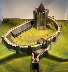 A model of a castle in a glass case
Description automatically generated