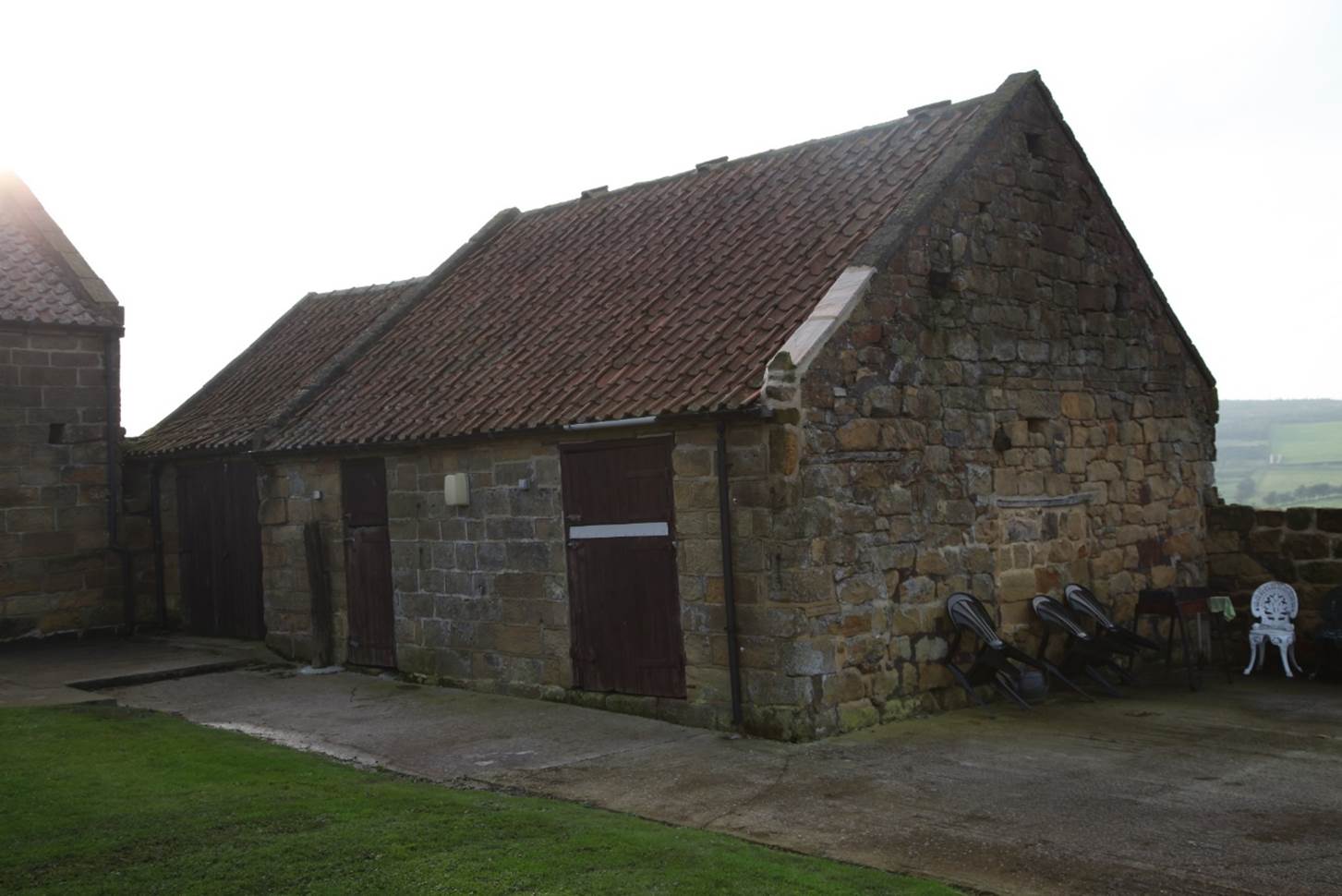 A stone building with a red roof
Description automatically generated
