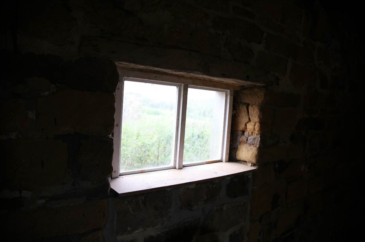 A window in a stone wall
Description automatically generated
