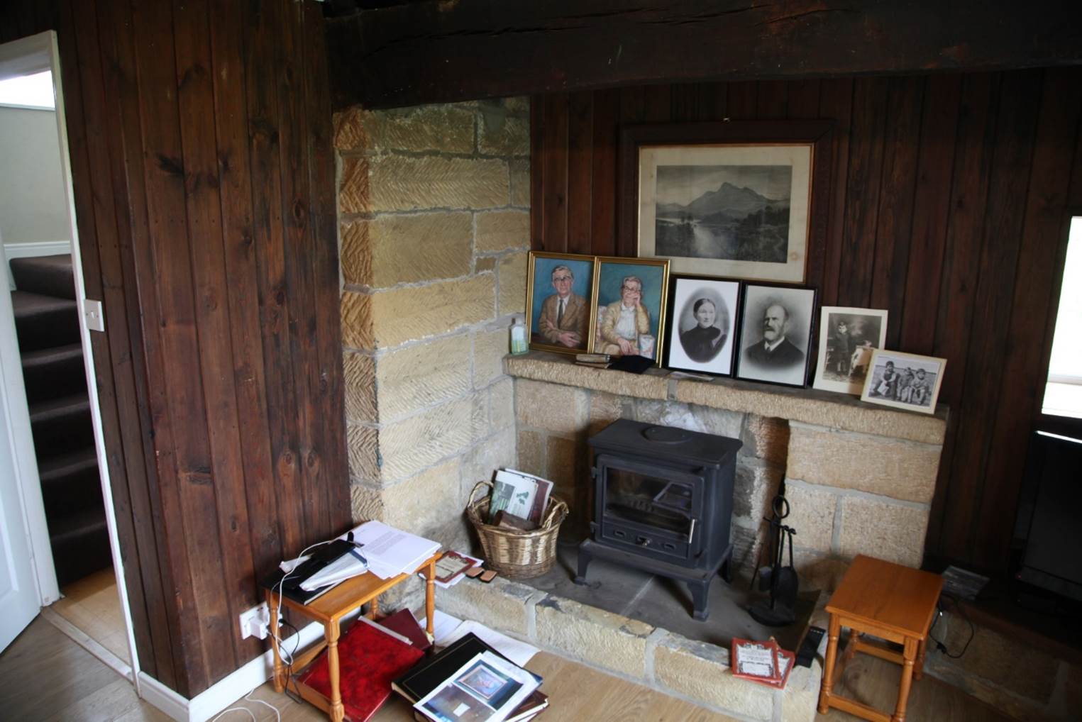 A room with a fireplace and pictures
Description automatically generated