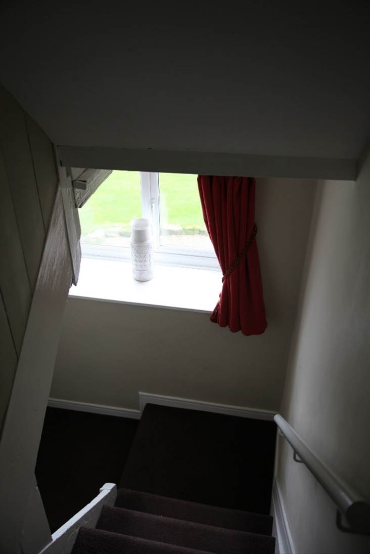 A red curtain on a window sill
Description automatically generated