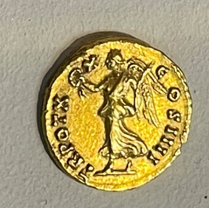 A group of coins on a shelf
Description automatically generated