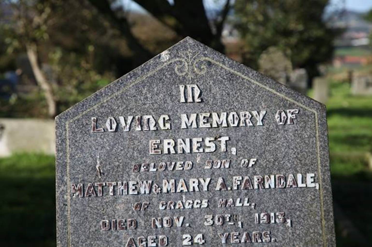 A close-up of a grave stone
Description automatically generated