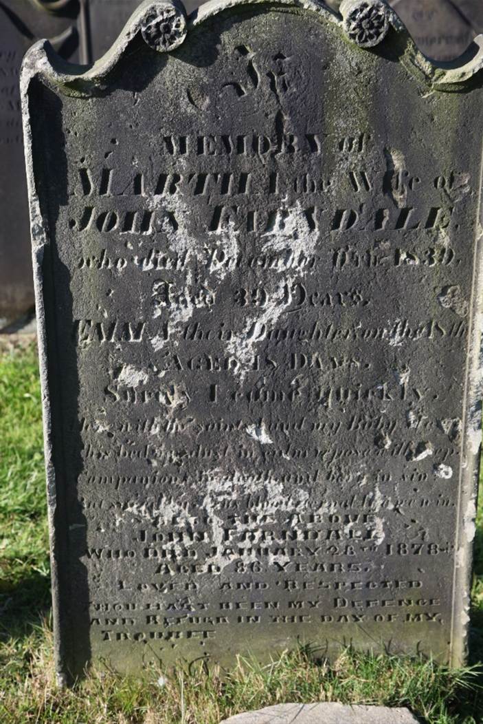 A tombstone with writing on it
Description automatically generated