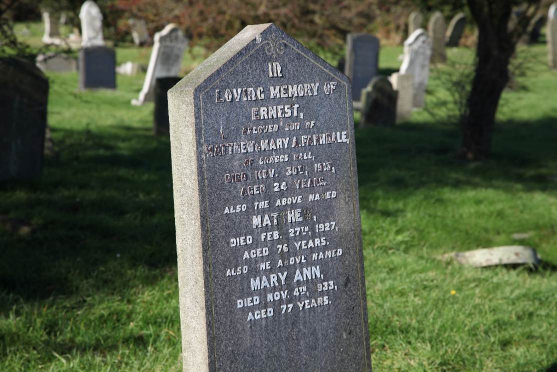 A tombstone in a cemetery
Description automatically generated