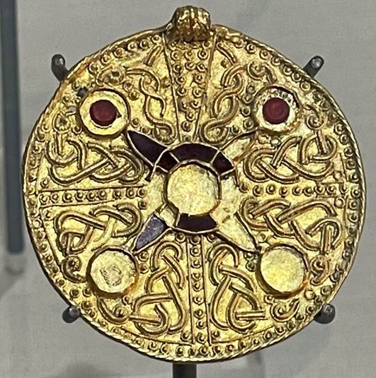 A gold circular object with a circular design
Description automatically generated with medium confidence
