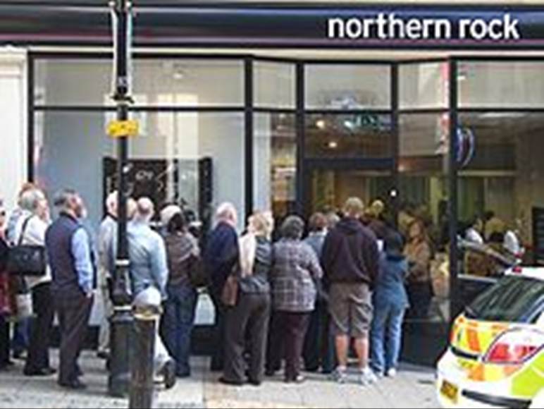 A group of people standing in a line outside a building
Description automatically generated