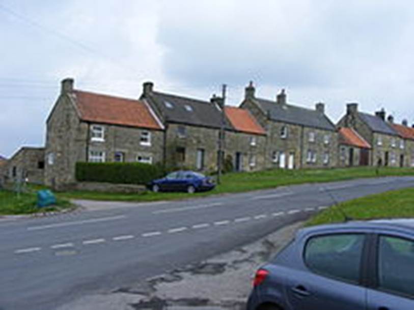 A row of houses on a street
Description automatically generated