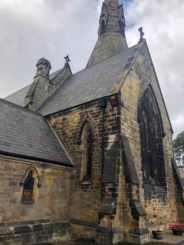 A stone building with a steeple
Description automatically generated