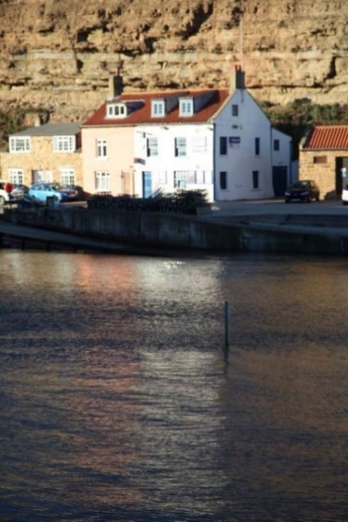 A body of water with a building in the background
Description automatically generated