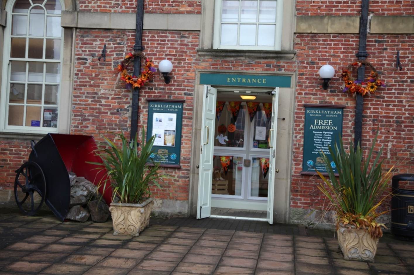 A brick building with a door
Description automatically generated