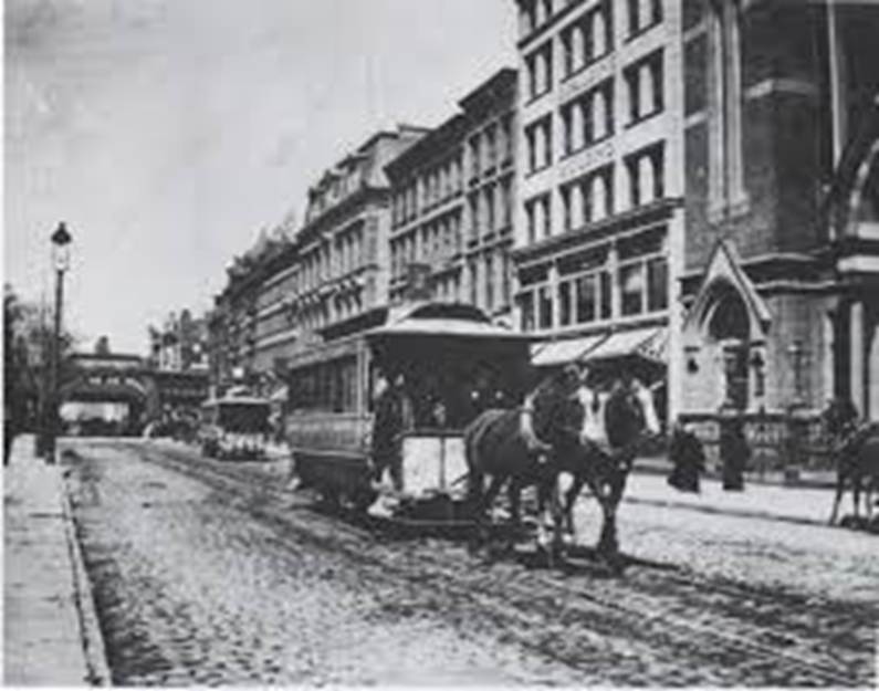 A horse drawn trolley on a street
Description automatically generated