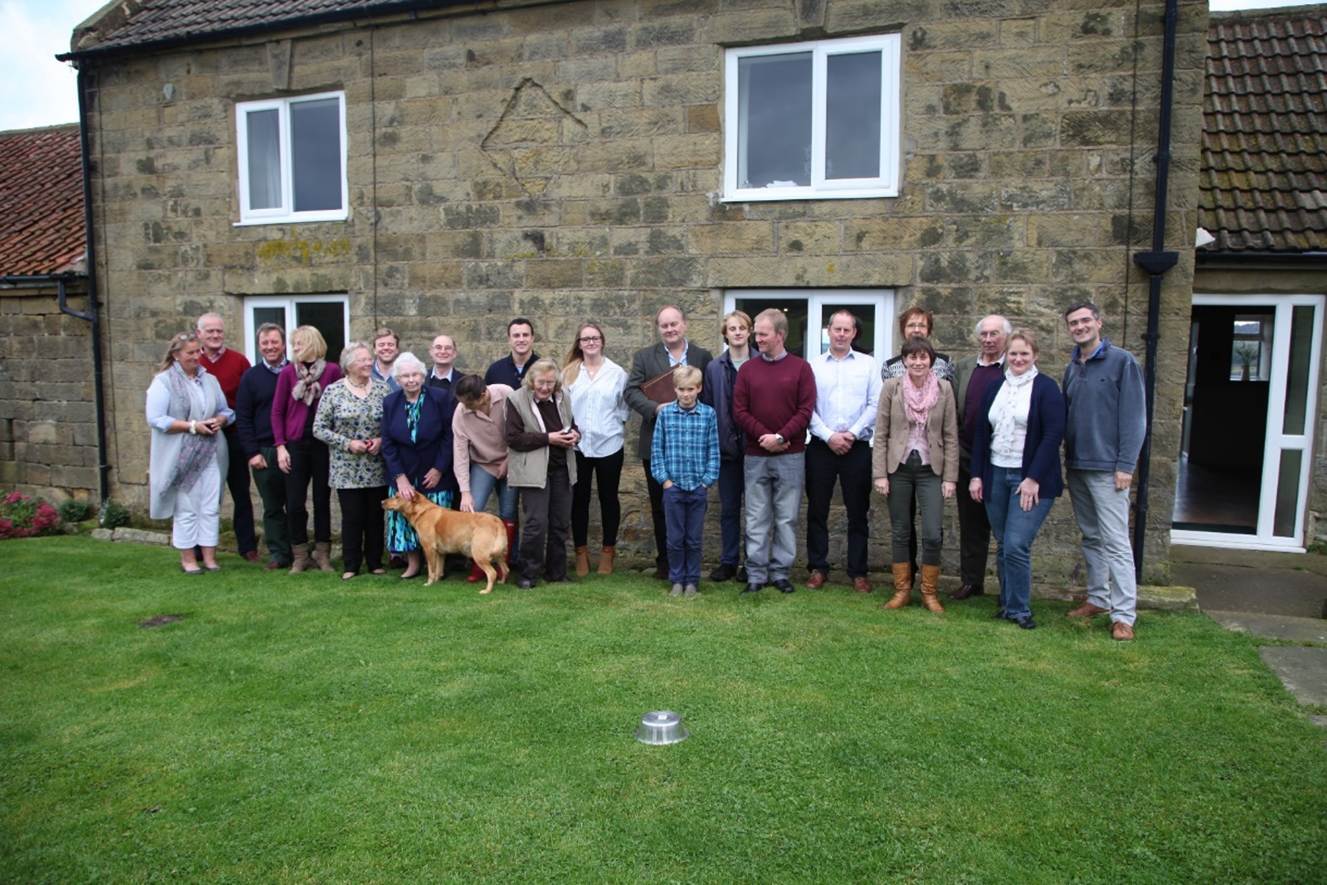 A group of people standing in front of a building
Description automatically generated