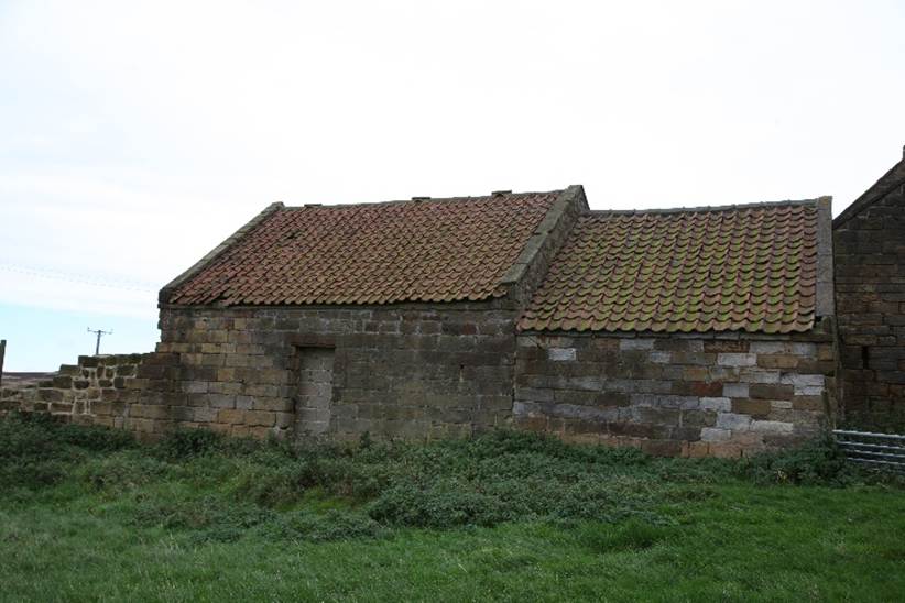A stone house with a red roof

Description automatically generated