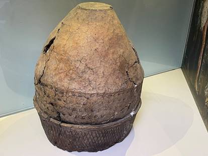 A large stone pot on a white surface

Description automatically generated